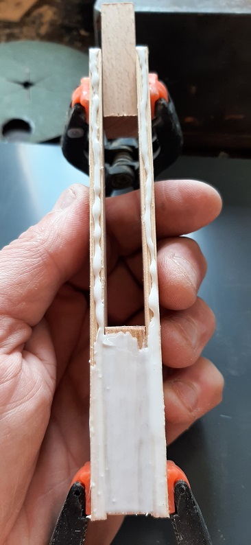 Figure 2 — A thin pipe box glued up on a flat caul with the loose front used as a spacer and weighted with lead-filled cans