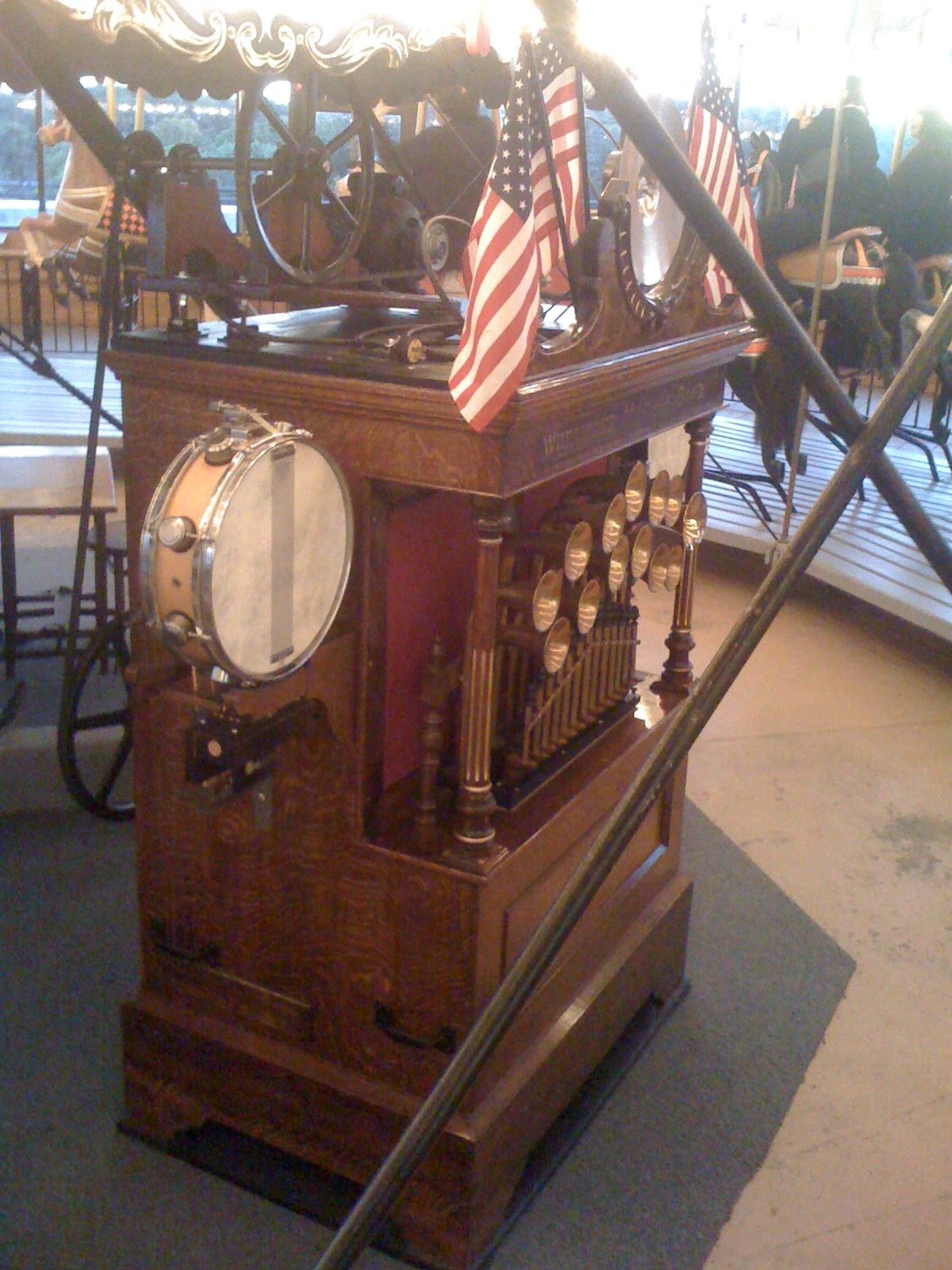 Figure 2 — A Wurlitzer band organ on a carousel, the perforated paper-roll frame visible behind the façade