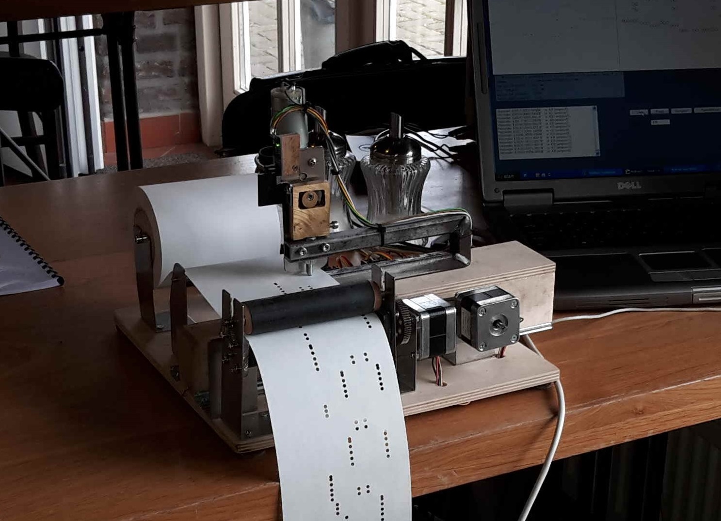 Figure 3 — A shop-made computer-driven punching machine: an Arduino-and-stepper X-Y table that punches note holes into a paper strip from a G-code file.