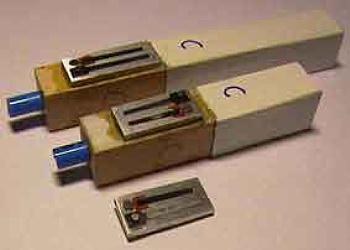 Figure 3 — A completed home-made free-reed "trumpet" pipe: a beeswax-mounted reed-plate on a wood block carrying a rolled, papered and painted cardboard resonator with its sliding stopper