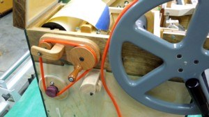Figure 3 — A round polyurethane drive belt seated in the groove of the driving/winding wheel — the groove cut "for a motor drive" that lets a gearmotor turn the same wheel the hand crank uses.