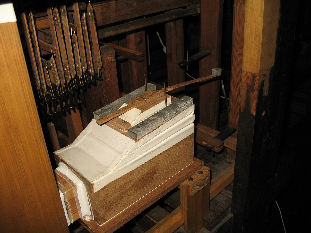 Figure 2 — A pipe-organ tremulant: a spring-and-weight loaded valve tapped into the wind trunk that bobs at a few hertz to pulse the wind pressure, producing vibrato in every pipe drawn through it.